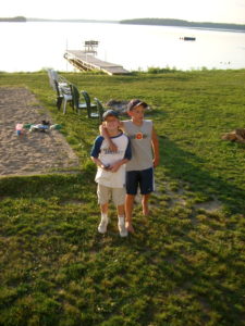 Two guests standing on the rocky lakeshore