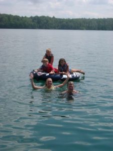 Two children paddling an inflatable boat