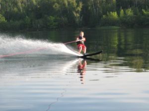 Water skier crossing the calm surface of Wabana Lake