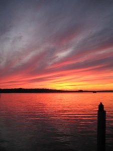 Dramatic red sunset over Wabana Lake and a dock post