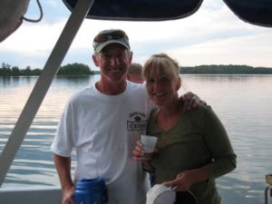 Guests standing beneath a pontoon canopy with the lake behind them