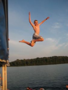 Young wakeboarder flipping from the dock