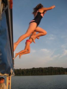 Young wakeboarder leaping beside the dock