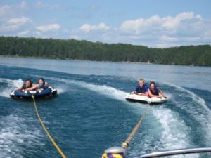 Two groups tubing behind a boat on Wabana Lake