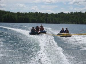 Guests tubing behind a boat on Wabana Lake