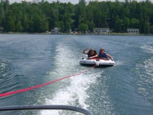 Riders tubing behind a motorboat