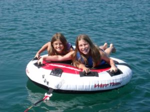 Two children riding an inflatable tube