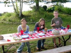 Children painting rocks at a picnic table