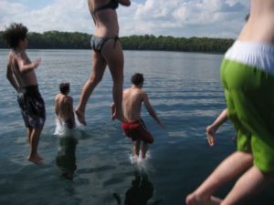 Children jumping from a dock into Wabana Lake