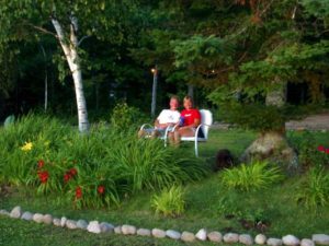 Stacey and Clint relaxing beside lakeside flowers