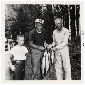 Three resort guests displaying their catch in July 1959