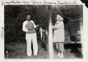 John and Lorraine displaying fish beside a vintage automobile